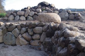 Trockenmauerterrassen mit Feldsteinen, einem Sitzstein und Steinhaufen. Ausmagerung mit Kies - Bauphase